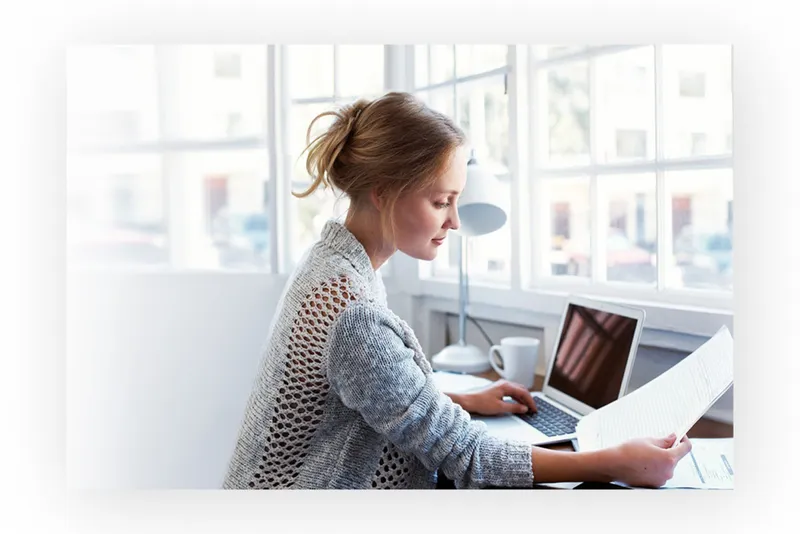 A woman reviewing a document at her laptop
